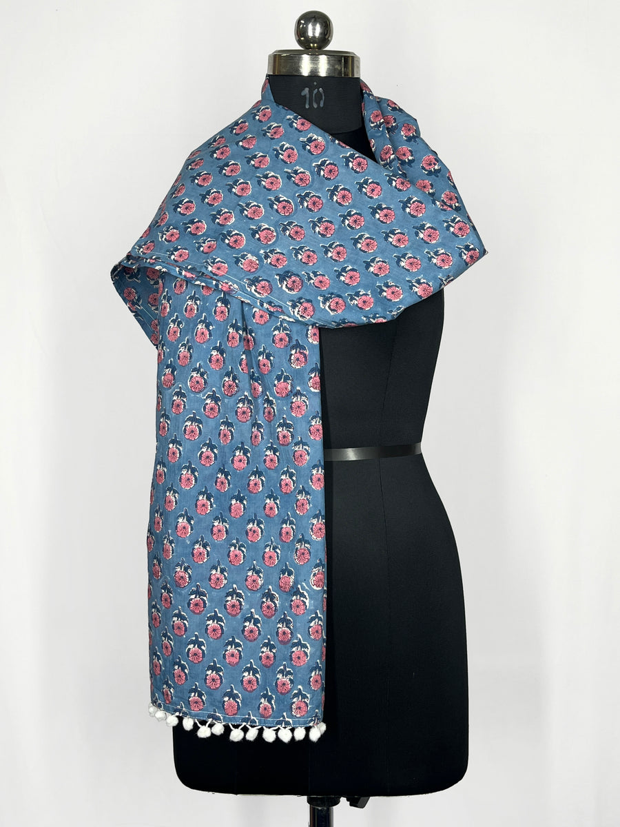 Pom-pom edging and a blue floral print scarf make this accessory lightweight and fashionable